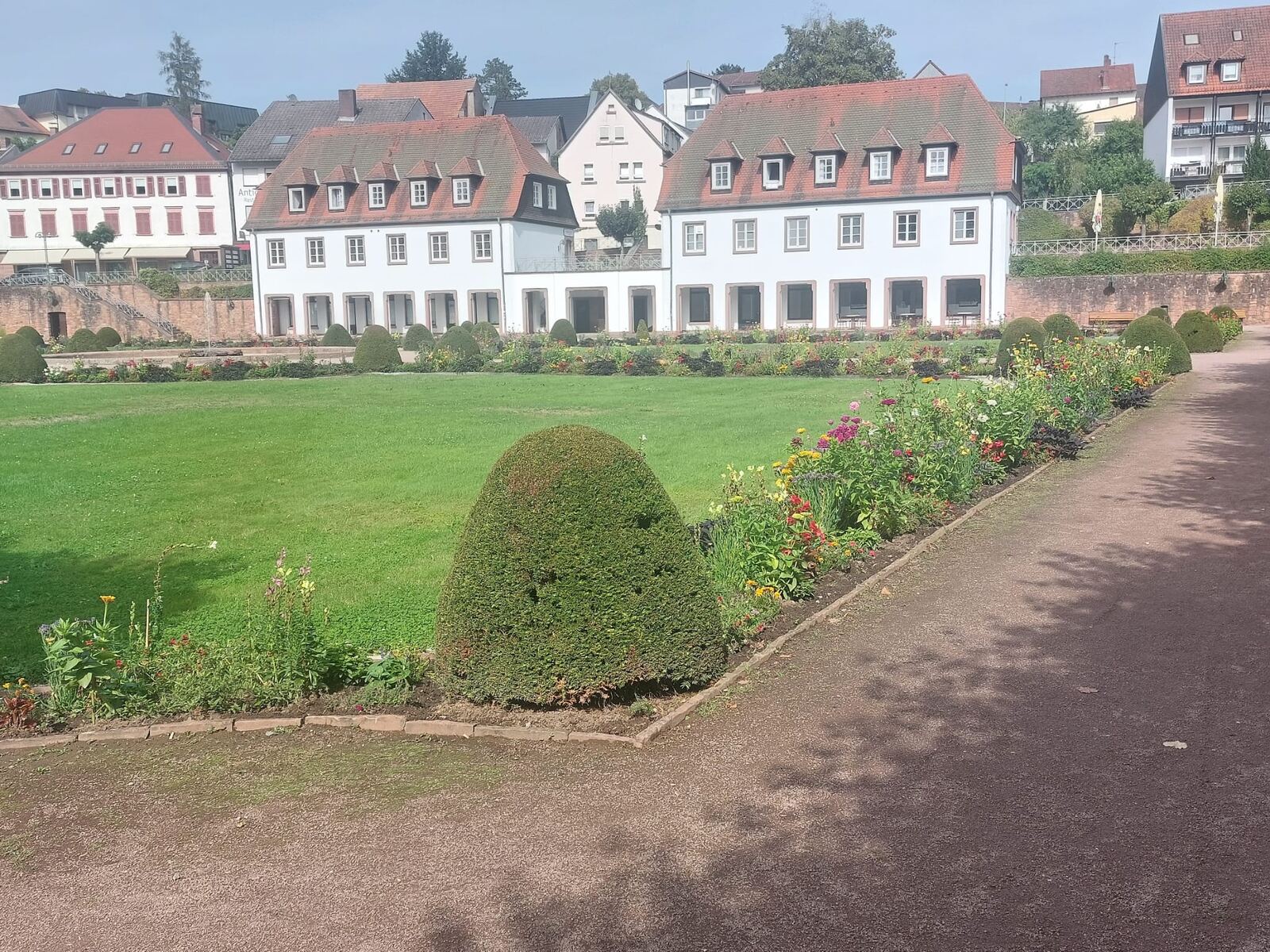 Weite Rasenfläche im Schlossgarten von Erbach mit Blumenbeeten und Altstadt im Hintergrund